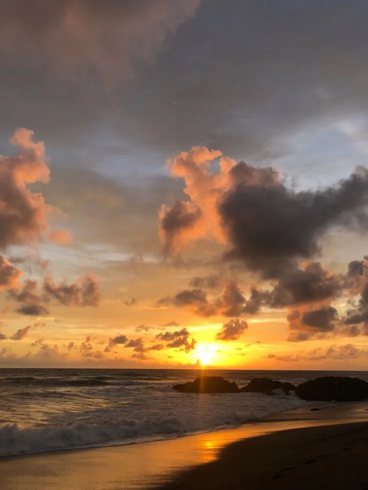 Sonnenuntergang am dunklen Strand von Seseh